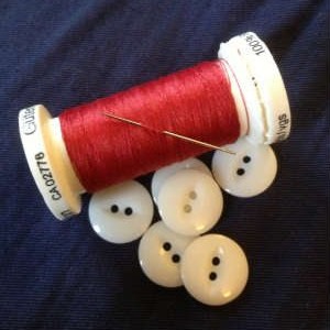 Red needle and thread on trousers with braces buttons