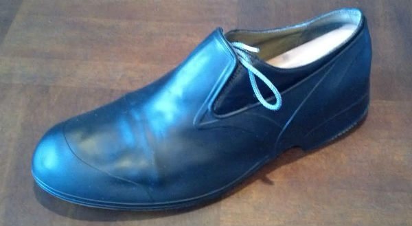 Rubber overshoe covering a black oxford