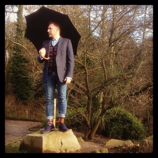 Well dressed man under vintage umbrella