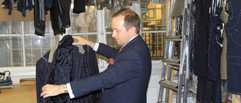 man inspecting bespoke suit jacket in London
