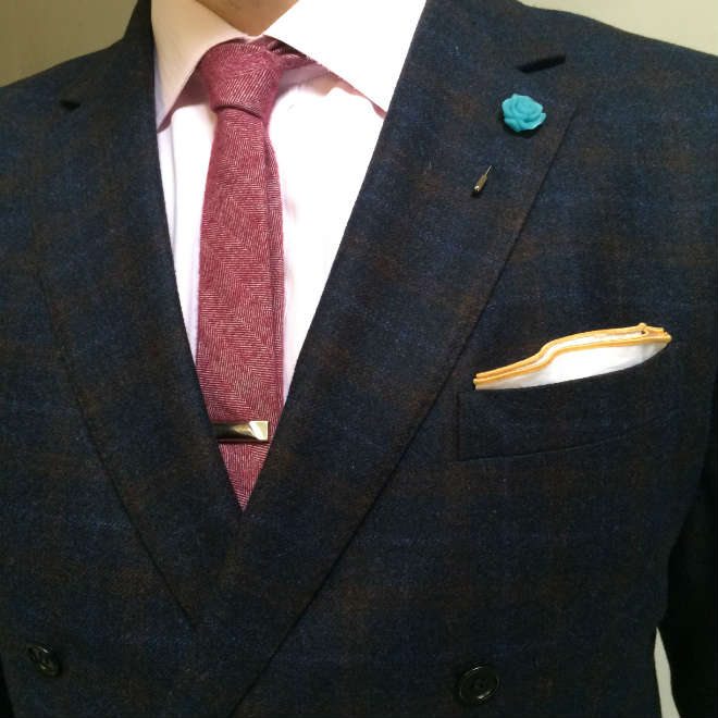 Upper suit details with lapel pin