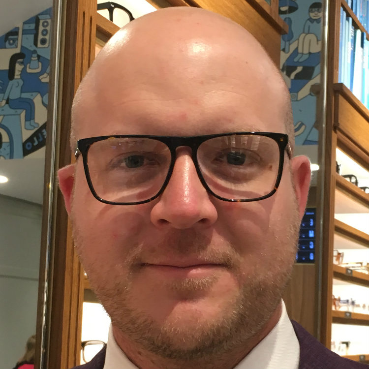 bald man in flat top glasses