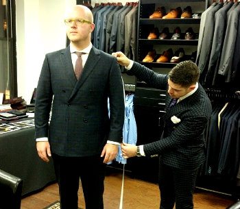 Man getting fitted in suit by tailor