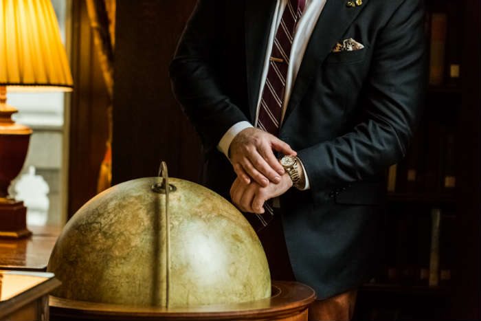 Gold and silver Rolex Daytona next to globe