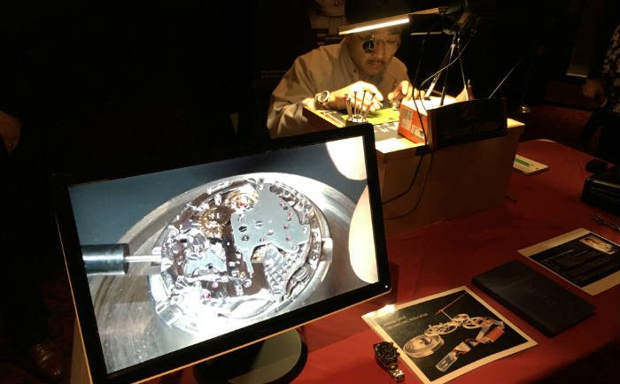 Watchmaker looking at baseplate of movement