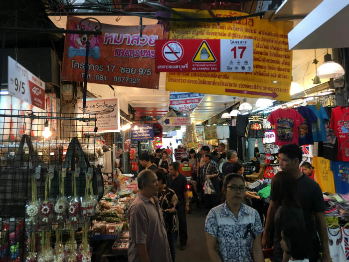 Moped riding through center of market stalls
