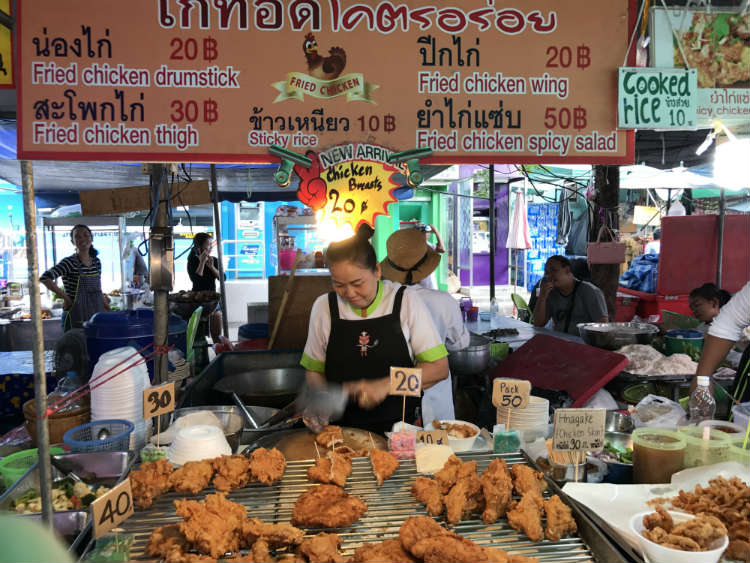 Woman chopping chicken on market stall