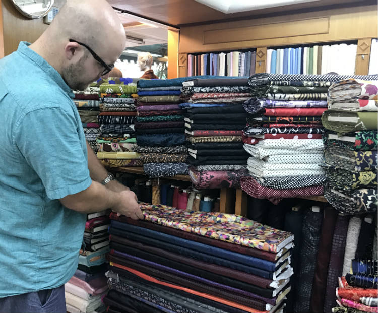 Looking at bolts of fabric for suit jackets