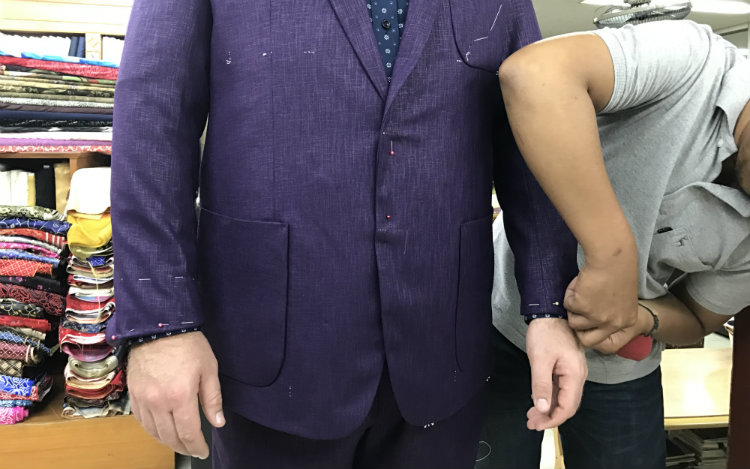 Tailor pinning sleeves on linen jacket