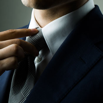 A Fashionable Man In Suit & Straightening Tie July 2015