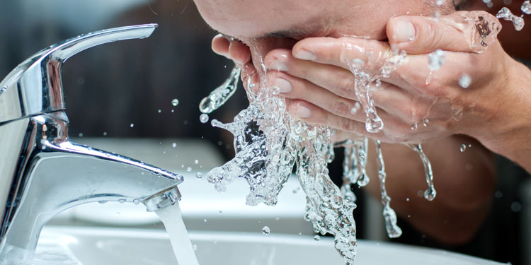 A Man Splashing Face With Water