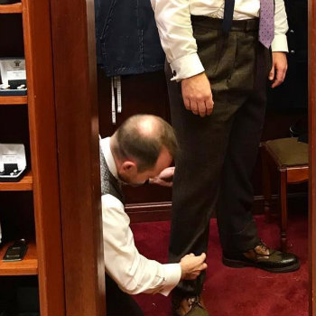 Main In Pleated Pants Getting Measured