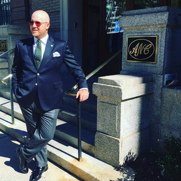 Man Leaning On Stone In Jacket And Trousers