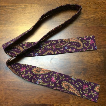 Purple Paisley Bow Tie On Wood Background