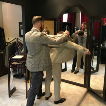 Man Helping Customer Into Suit Jacket
