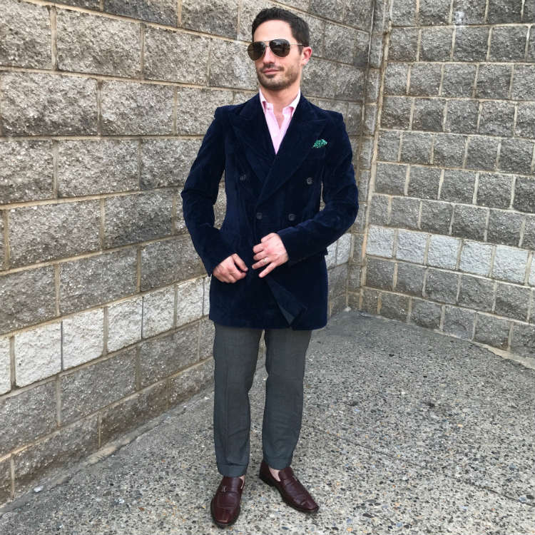 Man in blue blazer against stone wall