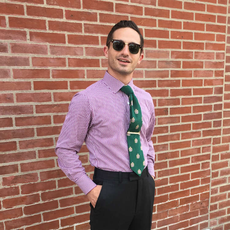 Man in purple shirt against brick