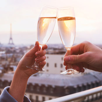 Couple Toasting Champagne Glasses In Front Of The Eiffel Tower