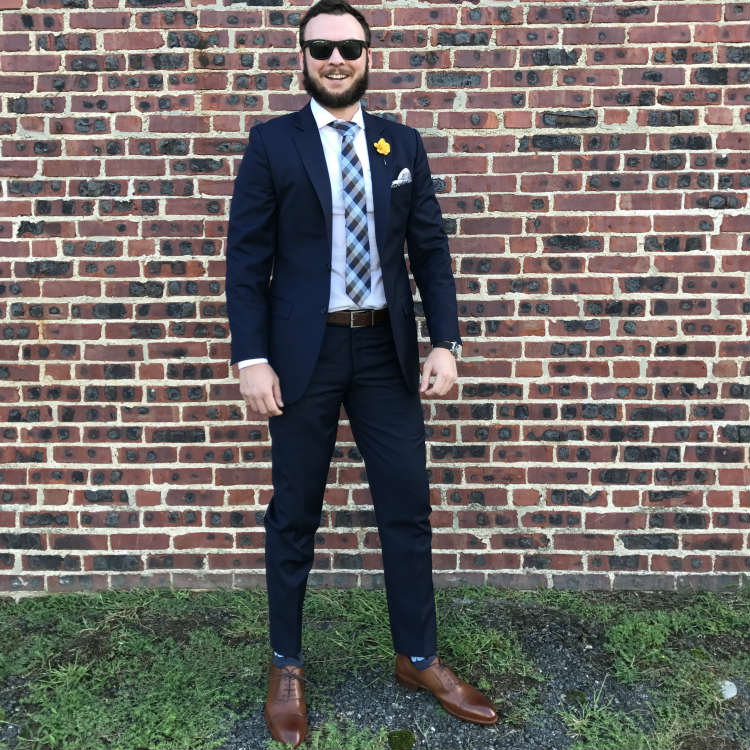 Man in brown shoes against brick wall