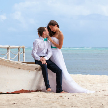 Newlyweds-Sitting-On-Boat-On-Beach