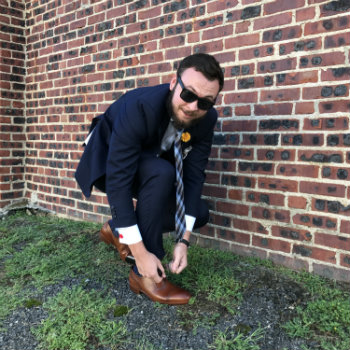 man tying brown shoes