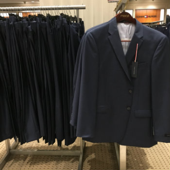 various suits on hangers in store