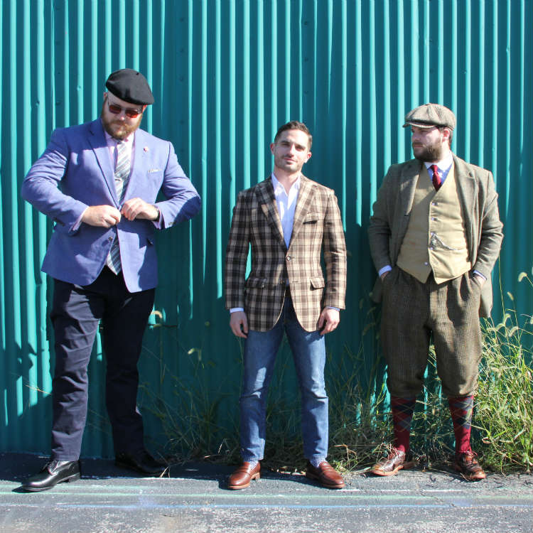 3 men in front of green wall