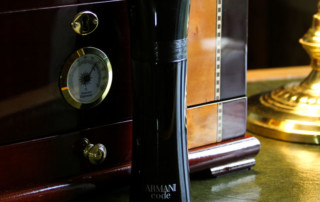 Armani Code Bottle On Old Desk With Humidor