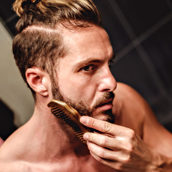 Hipster Combing Beard In Bathroom