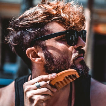 Hipster Combing Beard Outside