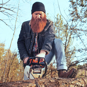 Lumberjack With Red Beard Sawing Tree