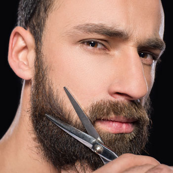Man Trimming Beard With Scissors October
