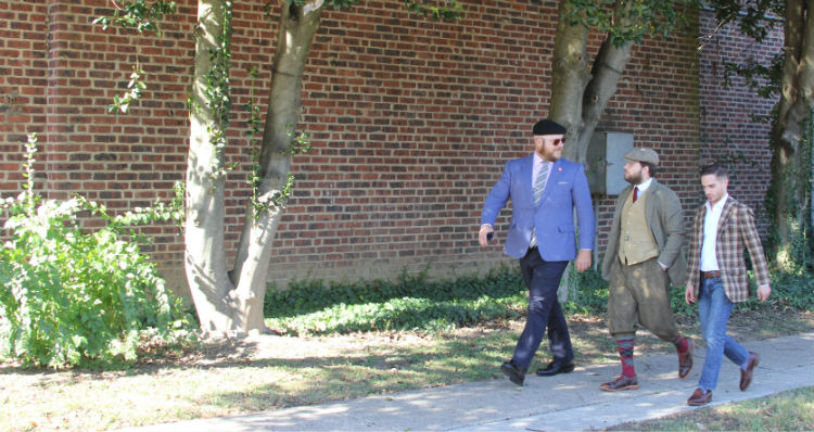 Three men walking on sidewalk