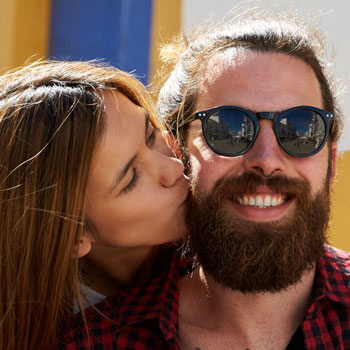 Woman Kissing Bearded Man On Italian Scooter