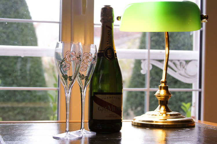 GH Mumm Cordon Rouge Champagne Bottle On Leather Desk With Flutes