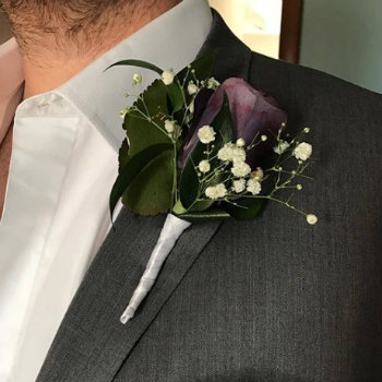 purple boutonniere in grey jacket