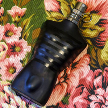 jean paul gaultier ultra male bottle lying on floral textile