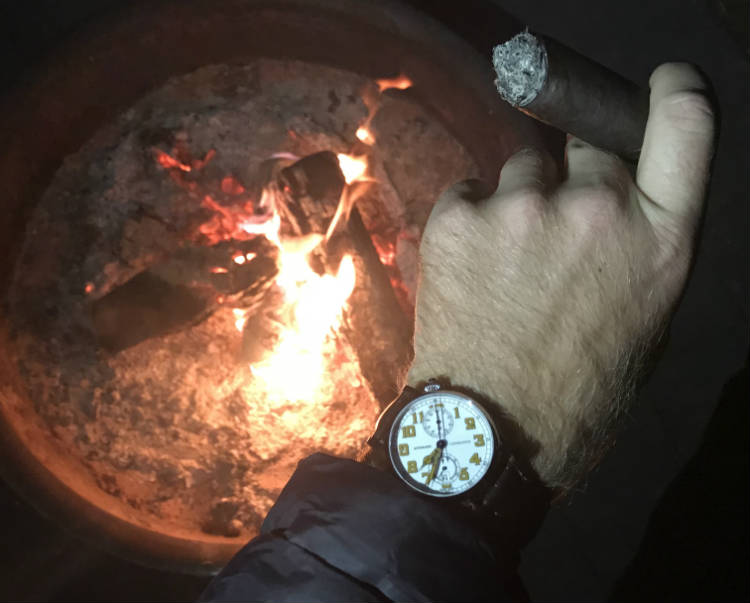 Longines watch by fire pit and cigar