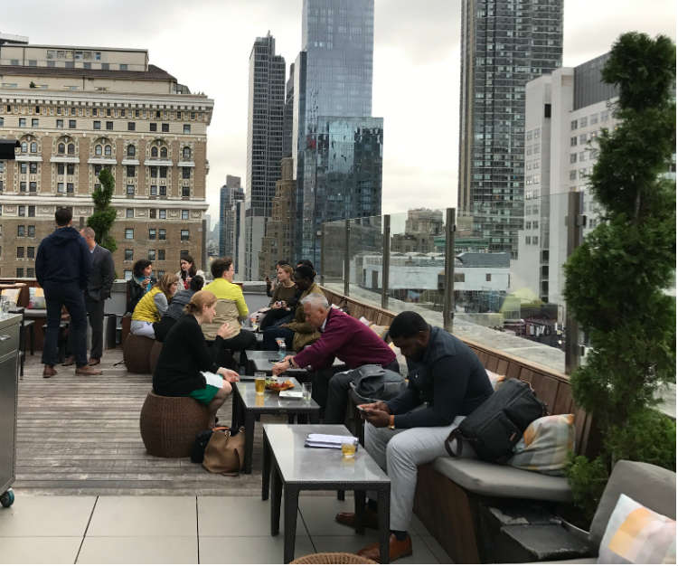 People On Patio Furniture At Rooftop Bar