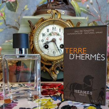 Terre d'hermès bottle & packaging in front of clock