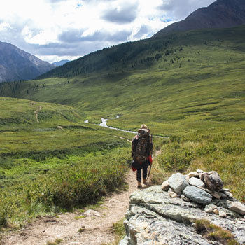 Hiking On Valley Path Between Mountains