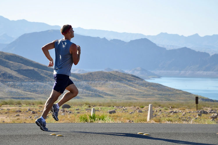 man jogging by lake & mountains