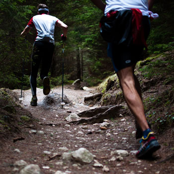 men trail running in forest