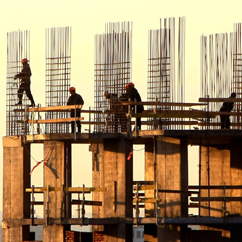 Silhouette Of Construction Workers On Building