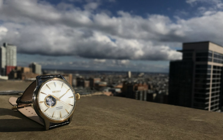Sun shining on a watch with city skyline behind