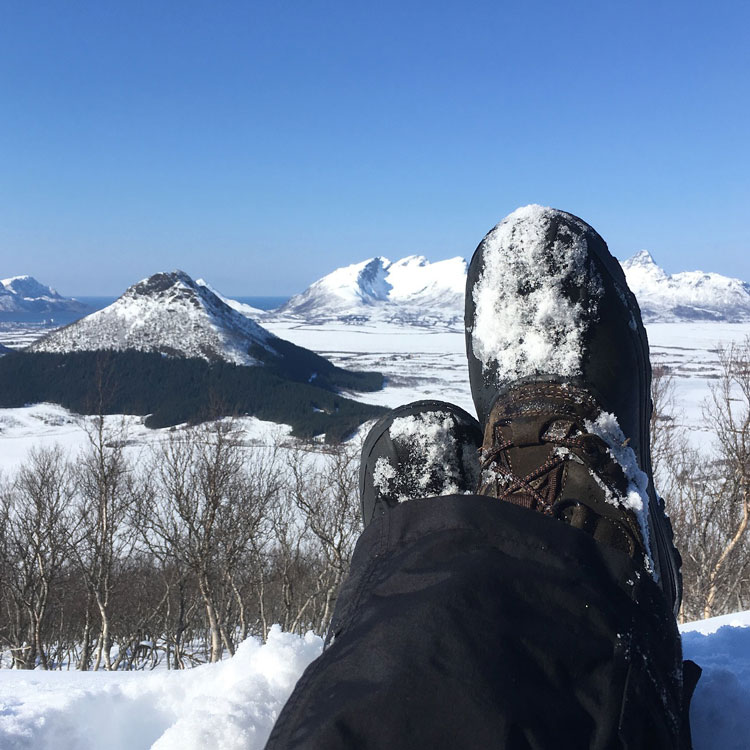 Snow boots over winter mountain landscape