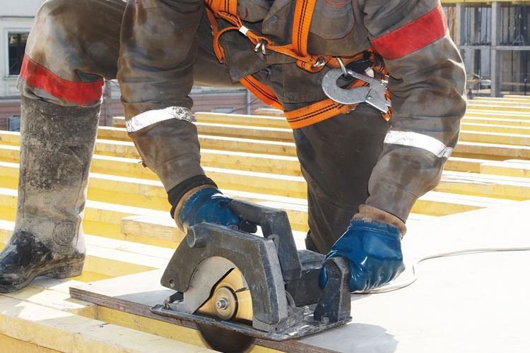 Builder Using Circular Saw On Roof