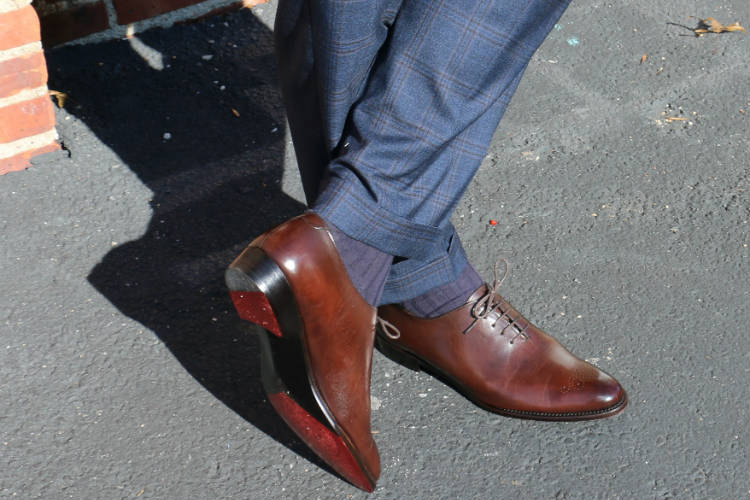 brown wholecut shoes with blue trousers