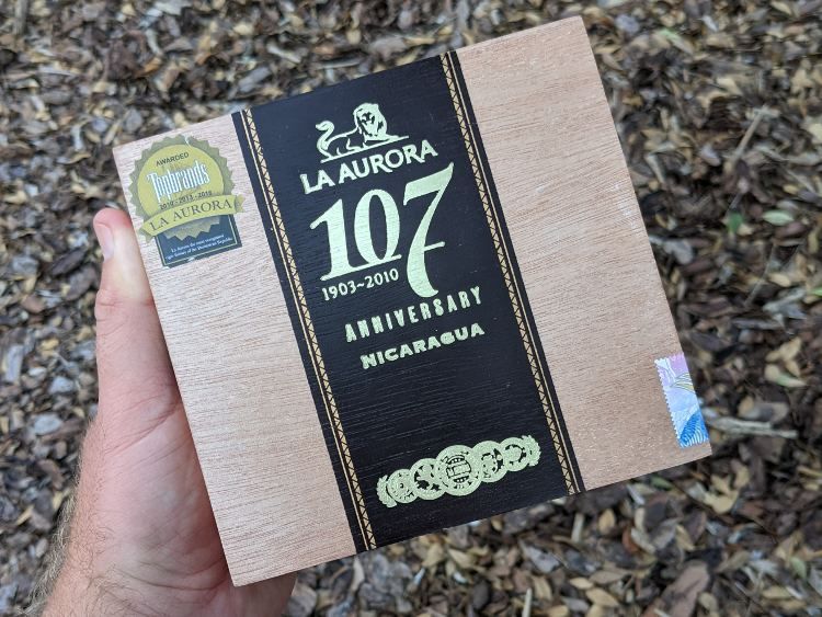 Top View Of La Aurora Cigars Box In Hand