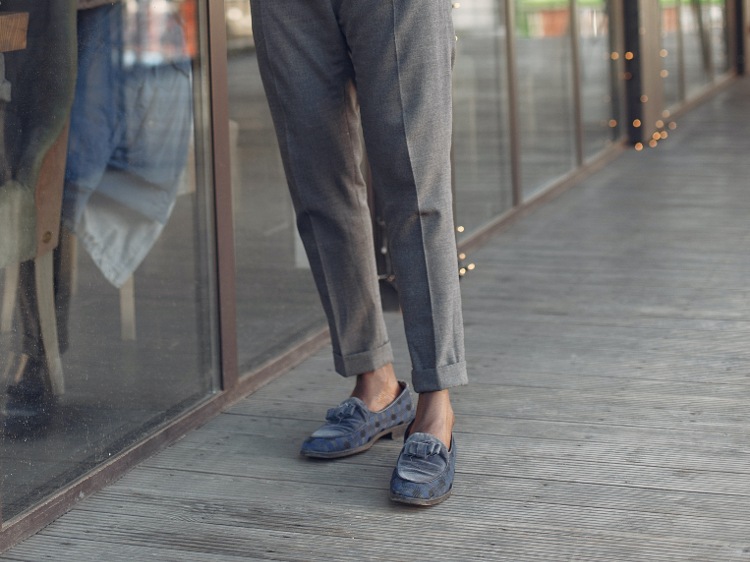 Man wearing moccasin shoes with gray trousers